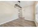 Open dining space with stylish light fixture and wood-look floors, seamlessly connected to other rooms at 4189 Homestead Dr, Lakeland, FL 33810