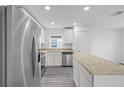 Bright kitchen featuring stainless appliances, white cabinets, granite countertops, and an island with storage at 431 Caribbean Ct, Poinciana, FL 34759