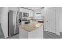 Modern kitchen with stainless steel appliances, granite countertops, and an island with extra storage at 431 Caribbean Ct, Poinciana, FL 34759