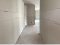 View of a unfinished hallway lined with drywall ready for customization and featuring a glimpse of natural light at 2244 Broadbrook Drive, St Cloud, FL 34771