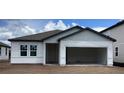 New construction home featuring a garage, double windows, and light gray siding at 2373 Broadbrook Drive, St Cloud, FL 34771