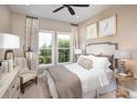 Inviting bedroom with soft lighting, decorative pillows, and a view to the outdoors through bright windows at 852 Arbor Green Trl, St Cloud, FL 34771