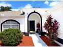 Inviting entryway with sleek black and white design, colorful landscaping, and a modern black front door at 2526 Sage Dr, Kissimmee, FL 34758