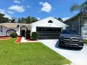 Beautiful single-story house with a black two-car garage, stylish door accents, and lush green lawn at 2526 Sage Dr, Kissimmee, FL 34758