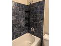 Updated bathroom with dark blue tile and built-in shelving at 422 22Nd Sw St, Winter Haven, FL 33880