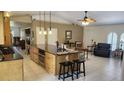 Open-concept kitchen with a large center island, granite countertops, and modern pendant lighting at 2514 Sage Dr, Kissimmee, FL 34758