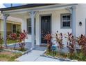 Inviting house exterior featuring a covered porch, gray columns, and landscaping at 233 Rosselli Blvd, Davenport, FL 33896