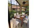 Outdoor dining on a screened patio with a ceiling fan and a view of trees at 2928 Lake Pineloch Blvd # 17-26, Orlando, FL 32806