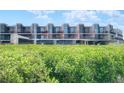 Condo building with water views and lush vegetation at 520 S Peninsula Ave # 2D7, New Smyrna Beach, FL 32169