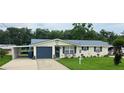 Charming single-story home with a well-manicured lawn, neutral paint, and a convenient carport at 1628 Paradise Ln, Astor, FL 32102