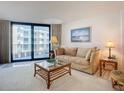 Cozy living room features a balcony, comfortable seating, and a glass coffee table at 1415 Ocean Shore Blvd # 309, Ormond Beach, FL 32176