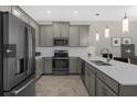 Well-lit kitchen with stainless steel appliances, gray cabinets, and white countertops at 505 Ocean Course Ave # 505, Davenport, FL 33896