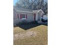 Gray house with red shutters, nicely landscaped yard at 612 E Plymouth Ave, Deland, FL 32724