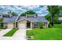 Charming single-story townhome featuring an attached garage, front lawn, and covered entryway at 34 Fairway Dr # 1, Debary, FL 32713