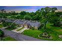 Aerial view of townhomes with manicured lawns and mature trees backing up to a tranquil pond at 34 Fairway Dr # 1, Debary, FL 32713