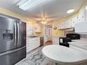 Bright kitchen with black appliances, white cabinets, and a gray and white rug at 824 Silver Oak Ave, The Villages, FL 32159