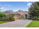 House exterior featuring a brick driveway and well-manicured lawn at 210 Brookgreen Way, Deland, FL 32724