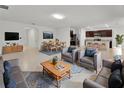 Open-concept living room with modern furniture, a dining area, and a stylish kitchen with stainless steel appliances at 317 Nowell Loop, Deland, FL 32724