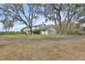 Large home with three car garage situated on a sprawling lawn with a paved driveway and mature landscaping at 1440 Arroyo Vista Dr, Deland, FL 32724