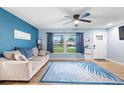 Bright living room featuring wood-look tile floors and comfy seating at 1412 Ruthbern Rd, Daytona Beach, FL 32114