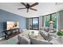 Bright living room features modern decor, ceiling fan, and sliding glass doors to a balcony with ocean views at 2555 S Atlantic Ave # 207, Daytona Beach Shores, FL 32118