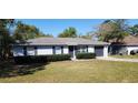 Charming single-story home with gray siding, manicured hedges, and a well-maintained front yard at 250 Hickory Ave, Orange City, FL 32763