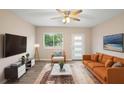 Inviting living room with neutral tones, modern furnishings, ceiling fan and bright natural light at 522 Powers Ave, Port Orange, FL 32127