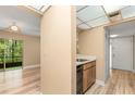 Cozy foyer leading to the kitchen and dining area, featuring wood-look floors and a sliding glass door to the outside at 140 Orchid Woods Ct # 11A, Deltona, FL 32725
