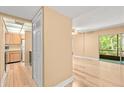 Open-concept living space with wood-look floors, adjoining kitchen, and sliding doors to a patio with wooded views at 140 Orchid Woods Ct # 11A, Deltona, FL 32725