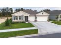 Two-story house with gray siding, stone accents, and a two-car garage at 3295 Arch Ave, Ormond Beach, FL 32174