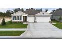 Two-story house with gray siding, stone accents, and a two-car garage at 3295 Arch Ave, Ormond Beach, FL 32174