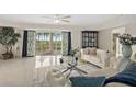 Bright living room features an open floor plan, tile floors, and access to a private balcony overlooking manicured grounds at 4650 Links Village Dr # C303, Ponce Inlet, FL 32127