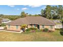 Brick house with brown roof, landscaping, and large yard at 113 Amberglow Ct, Debary, FL 32713
