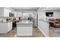 Modern kitchen featuring white cabinets, stainless steel appliances, granite countertops, and a convenient kitchen island at 1640 Juno Trl # 205A, Astor, FL 32102