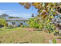 Landscaped front yard with mature trees and a charming home at 4430 Doris Dr, New Smyrna Beach, FL 32169