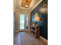 Inviting entryway with wood accent wall, designer lighting, console table, and patterned runner rug at 1227 Victoria Hills, Deland, FL 32724