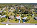 Scenic aerial view of a residential neighborhood, showcasing a home with lush green landscaping and surrounding trees at 1437 Colin Kelly Ave, Daytona Beach, FL 32124