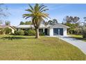 Inviting single-Gathering home with lush front yard, a palm tree, and attached garage, offering a warm and welcoming feel at 1437 Colin Kelly Ave, Daytona Beach, FL 32124
