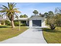 Garage view of a bright single-story house with a blue garage door and well-kept lawn, reflecting modern suburban living at 1437 Colin Kelly Ave, Daytona Beach, FL 32124