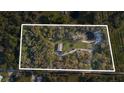 An aerial view of a secluded property surrounded by lush greenery with a pond at 227 N Putnam Grove Rd, Oak Hill, FL 32759