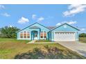 Charming, single-story blue home featuring an attached two-car garage and bright, welcoming curb appeal at 3190 Lori Ct, Deltona, FL 32738