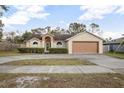 Single-story house with attached garage and neatly trimmed shrubs at 1267 Saxon Blvd, Deltona, FL 32725