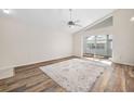 Spacious living room featuring wood-look floors, a ceiling fan, and access to a bright Florida room at 4619 Barnacle Dr, Port Orange, FL 32127