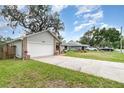 Well-maintained home showcasing a two-car garage and mature trees at 779 Victoria E Cir, Ormond Beach, FL 32174