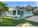 Charming single-story light blue home with a screened porch and well-maintained lawn and landscaping at 1146 Riverside Dr, Daytona Beach, FL 32117