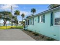 Side view of a charming light blue home with dark blue shutters, showcasing its unique architectural details at 1146 Riverside Dr, Daytona Beach, FL 32117