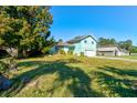 View of teal house from the yard, showcasing landscaping at 453 Merrimac Dr, Port Orange, FL 32127