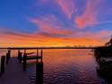 Scenic waterfront view with a wooden dock at sunset at 5178 Riverside Dr, Port Orange, FL 32127
