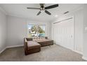 Cozy bedroom featuring a brown couch, ceiling fan, and ample closet space at 1275 Elkcam Blvd, Deltona, FL 32725