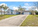 Ranch style home with a two-car garage and mature landscaping at 1275 Elkcam Blvd, Deltona, FL 32725